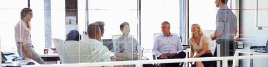 six people sitting together in a bright room are facing each other